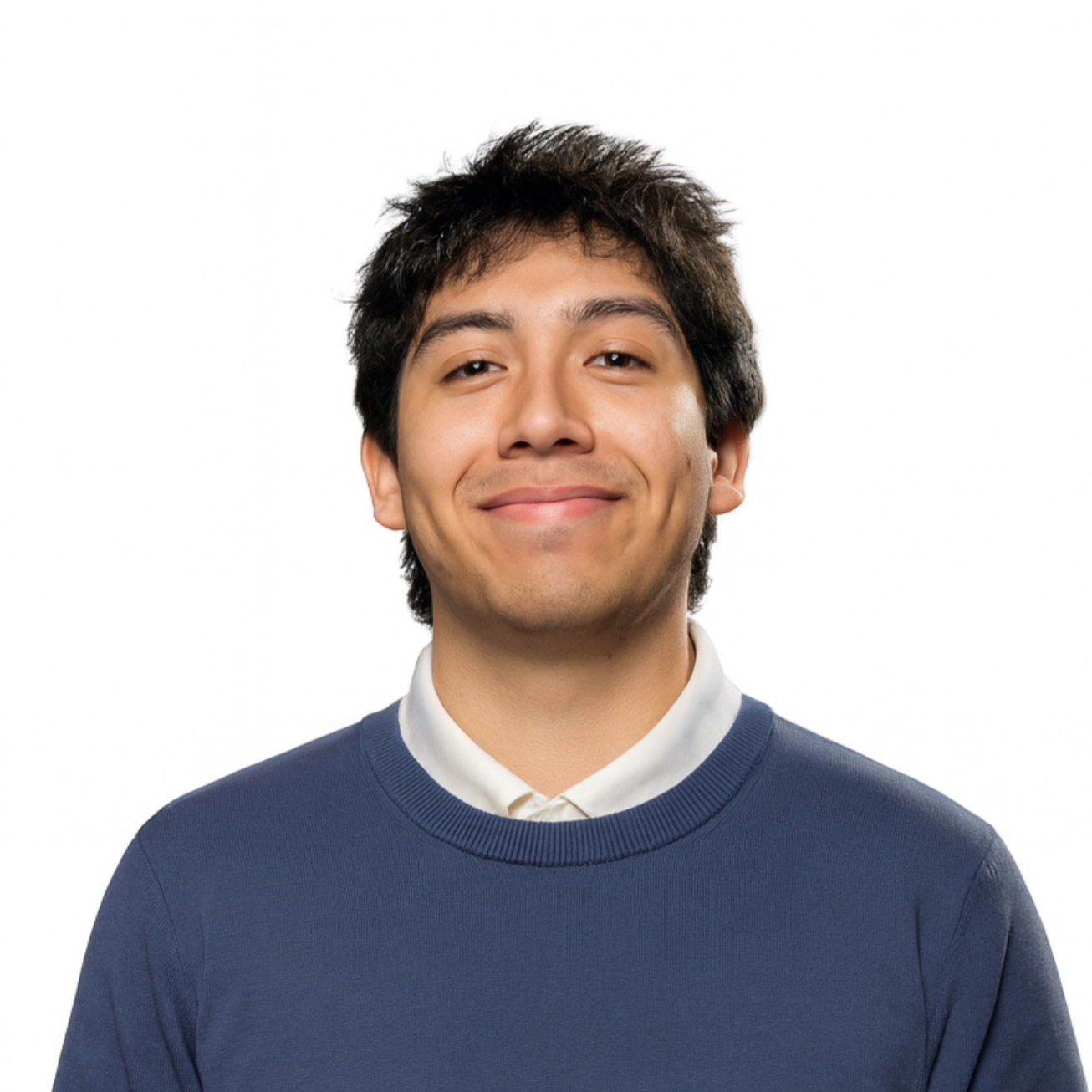 A young man with dark, messy hair, smiling slightly, standing against a plain white background.