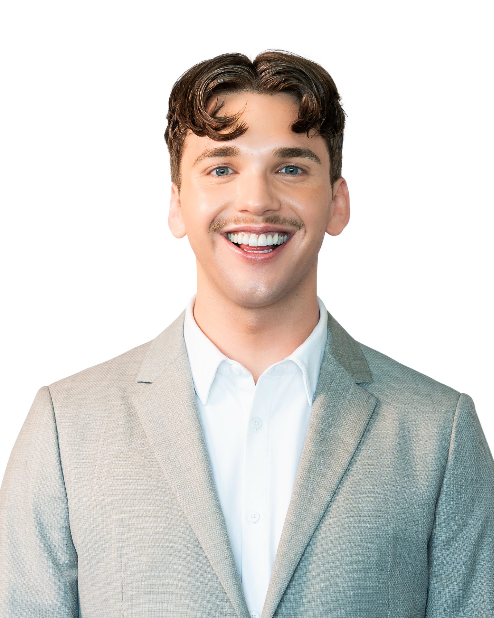A smiling young man with blue eyes and brown hair wearing a beige suit and white shirt.