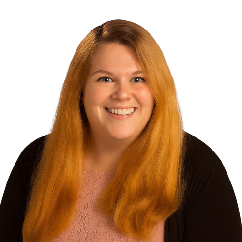Portrait of a woman with long red hair, blue eyes, and a friendly smile, wearing a pink lace top and a black cardigan, against a white background.